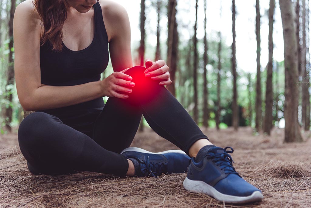 Woman experiencing knee pain whilst exercising